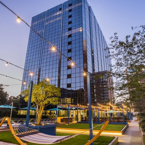 a park with a large glass building in the background